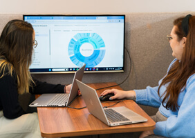 two digital marketers looking at a marketing report together